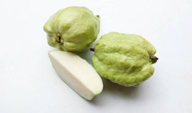 Taze yeşil çiğ guava (Psidium guajava L), beyaz arka planda izole edilmiş yapraklarla ikiye bölünmüş meyve. Tropikal egzotik meyve ve sağlıklı meyve