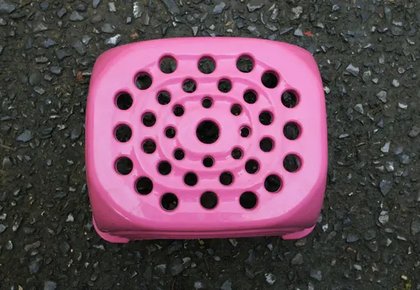 在洗衣服或洗碗的时候 用一把粉红色的小塑料椅子坐着 坐下来放松一下 水泥背景图 — 图库照片