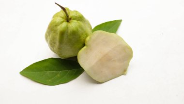 Taze yeşil çiğ guava (Psidium guajava L), beyaz arka planda izole edilmiş yapraklarla ikiye bölünmüş meyve. Tropikal egzotik meyve ve sağlıklı meyve