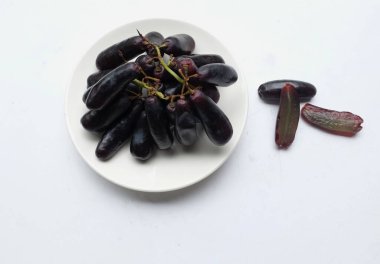 Bir demet taze çekirdeksiz ay çekirdeği üzümü, Mor Cadı Parmak üzümü, Sapphire üzümleri ya da beyaz arkaplanda izole edilmiş beyaz seramik bir elmaye üzümü. Siyah üzümler.. 