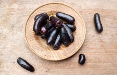 Bir demet taze çekirdeksiz ay çekirdeği üzümü, Mor Cadı Parmak üzümü, Sapphire üzümü ya da tahta sehpada izole edilmiş beyaz ahşap bir ağaçta cadı parmağı üzümü. Siyah üzümler.. 