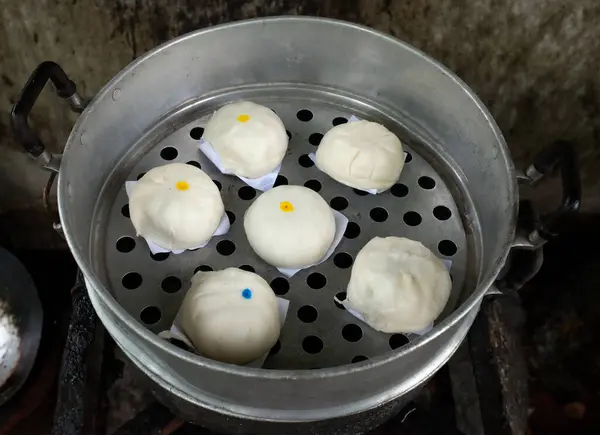 close up a homemade of steamed buns ( Chinese steamed buns ) ,stuffed steamed bun with pork filling, cream, sweet, red pork ,red beansin the steam pot . it taste delicious and suitable for breakfast.