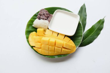 Lezzetli Tayland mangosu yapışkan pirinci taze ve olgun mango meyvesi seramik bir tabakta izole edilmiş yaz mevsiminde Tayland tatlısı glutinous rice, mango, hindistan cevizi sütü