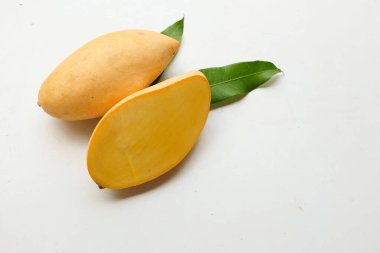 olgun sarı mango altın, mango nam dok mai mango, barakuda mango (mangifera indica) beyaz bir arka planda yapraklarla ikiye bölünmüş meyve kralı. Tropikal egzotik meyve ve sağlıklı meyve