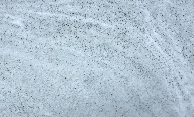 Deterjan köpüğü suyun içinde zemin zemininde. Çamaşır yıkadıktan ve temizledikten sonra beyaz köpük köpük deterjan dokusu..