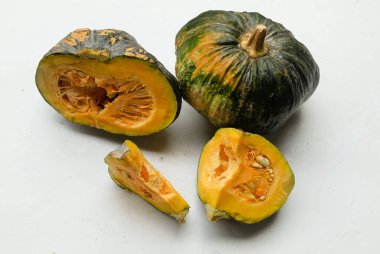 Bir yığın taze çiğ Japon balkabağı (Cucurbita moschata), Kabocha kabağı, beyaz bir arka planda izole edilmiş. Sağlıklı gıda sebze, meyve ve gıda ticareti fikri