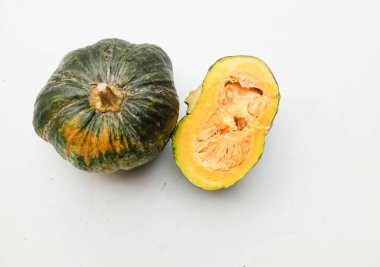 Bir yığın taze çiğ Japon balkabağı (Cucurbita moschata), Kabocha kabağı, beyaz bir arka planda izole edilmiş. Sağlıklı gıda sebze, meyve ve gıda ticareti fikri