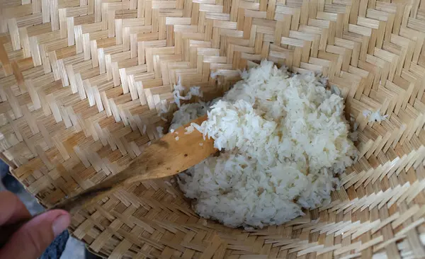 close up a woman asian Scoop hot sticky rice in an old wooden steamer, fragrant, very appetizingcook rice,sticky rice,hot sticky rice in old wooden steamer.