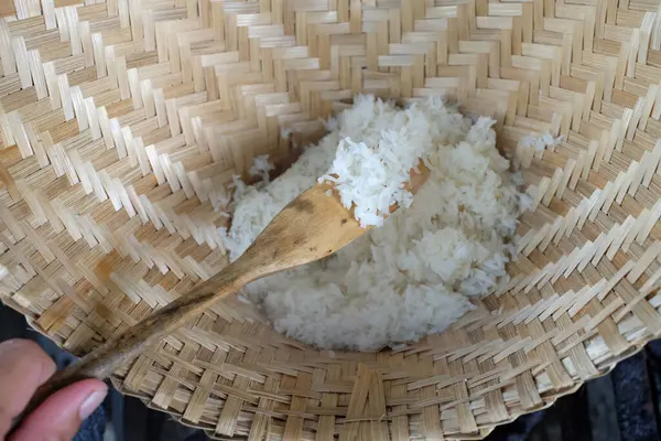 close up a woman asian Scoop hot sticky rice in an old wooden steamer, fragrant, very appetizingcook rice,sticky rice,hot sticky rice in old wooden steamer.