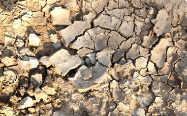 Toprak çatlakları ayrık ve hasarlı çatlaklar, kil ve kumla kurumuş toprağın dokusu. Çöl, Küresel Isınma, İklim Değişikliği. Kuraklık ve ölüm kavramı.