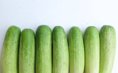 Taze çiğ organik salatalık (salatalık sativus) yeşil sebzeler beyaz bir arka planda izole edilir. Sağlıklı meyve, sebze, yiyecek konsepti