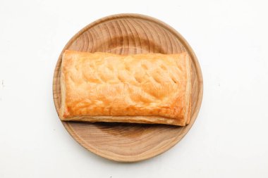 Image of Appetizing closely packed fresh square shaped puff pastry biscuit snacks with puffed crispy golden brown crust layersa In a wooden plate  isolate on a white backdrop. 