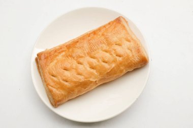 Image of Appetizing closely packed fresh square shaped puff pastry biscuit snacks with puffed crispy golden brown crust layersa In a white plate  isolate on a white backdrop. 