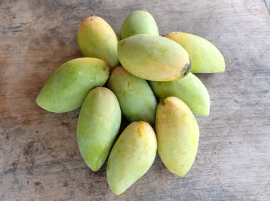 ripe yellow mango golden mango,yellow mango ,golden nam dok mai mango ,barracuda mango ( mangifera indica) king of fruits isolated on a wooden table background.tropical fruit in thailand