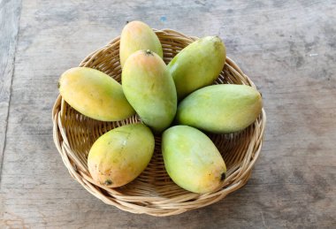 olgun sarı mango, sarı mango, sarı mango, altın nam dok mai mango, barakuda mango (mangifera indica) sepetin içindeki meyvelerin kralı ahşap bir masa üzerinde izole edilmiş. Tropikal meyve. 