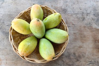 olgun sarı mango, sarı mango, sarı mango, altın nam dok mai mango, barakuda mango (mangifera indica) sepetin içindeki meyvelerin kralı ahşap bir masa üzerinde izole edilmiş. Tropikal meyve. 