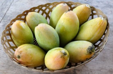 olgun sarı mango, sarı mango, sarı mango, altın nam dok mai mango, barakuda mango (mangifera indica) sepetin içindeki meyvelerin kralı ahşap bir masa üzerinde izole edilmiş. Tropikal meyve. 