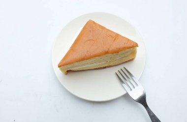  Üst manzara tabakta beyaz seramik tabakta çırpılmış kremalı iştah açıcı vanilyalı şifon pasta. Hafif, kabarık, renkli sünger keki. tatlı konsepti