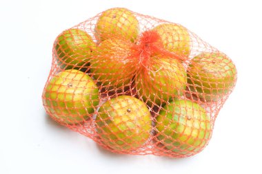 Taze, iştah açıcı portakallar plastik bir torba içinde meyve ya da beyaz bir arkaplanda izole edilmiş bir ağ torbası taşıyın.