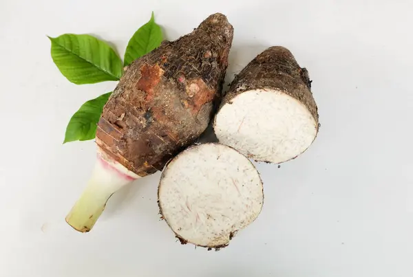 stock image Fresh raw organic Taro root ,taro fragrant ,(colocasia esculenta) whole and halfis and green leaf a large head type.with a pleasant smell isolate on a white backdrop.taro root ready to cooking food 