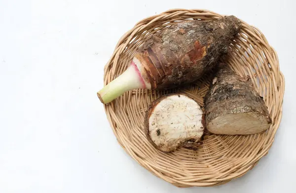 stock image Fresh raw organic Taro root ,taro fragrant ,(colocasia esculenta) whole and halfis in basket a large head type.with a pleasant smell isolate on a white backdrop.taro root ready to cooking food 