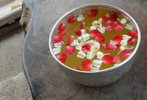 Buddha 'yı yıkamak için gümüş bir kase içinde yasemin çiçekleriyle bir gül yapraklarını kapatın. Songkran festivali ya da Tayland Yeni Yılı için