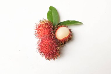 Taze olgun kırmızı rambutanlar (Nephelyum Lappaceum) bütün ve yarım ve yeşil yaprak beyaz bir arka planda izole edilir. Rambutan kırmızı kabuklu, beyaz etli, kahverengi tohumlu bir meyvedir. Tatlı bir tadı var.,