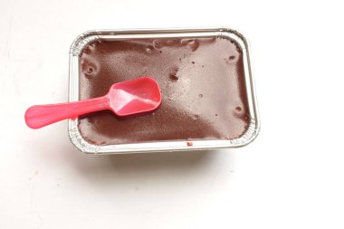 Üst görünüm alüminyum folyo kutusundaki iştah açıcı çikolatalı pasta beyaz bir arkaplanı izole eder. Hafif, kabarık, renkli sünger keki. tatlı konsepti