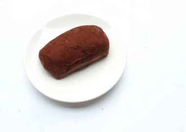 Üst görünüm iştah açıcı unsuz çikolatalı kek, çikolatalı unsuz kek beyaz bir tabakta düzenlenir beyaz bir arkaplan izole edilir. Hafif, kabarık, renkli sünger keki. tatlı konsepti