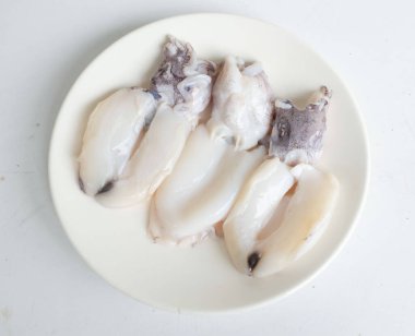 Taze çiğ deniz ürünleri mürekkep balığı, gökkuşağı mürekkep balığı, sepia brevimana, sepya firavunu beyaz bir zeminde izole edilmiş beyaz bir levhada. Deniz ürünleri yapmak için hammadde ya da malzeme