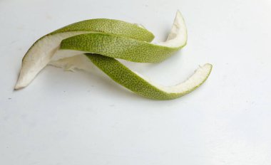 Taze yeşil sarmal şekilli yatay fotoğraf. Taze greyfurt kabuğu. (Citrus maxima) Merr) Beyaz bir arka planda izole edilmiş. Olgun greyfurt lezzeti, olgun narenciye meyvesi.