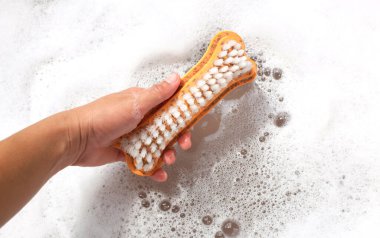 Çamaşır yıkama kabında çamaşır fırçalayan bir kadın eli. Çamaşır konsepti.