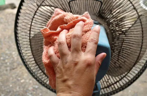 stock image horizontal photo of handmaid asian cleaning dirty fan blade with cloth.wipe, rub and wash.cleaning and hygiene care,Maintaining electrical appliances in the home concepts