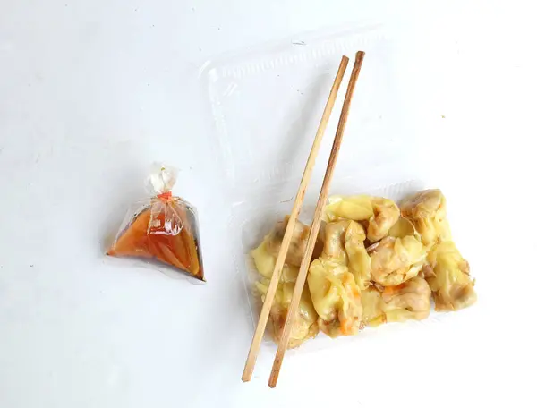 stock image Appetizing a Siu Mai, Shumai, Chinese steamed dumplings, dim sum in a In a clear plastic box container with soy sauce, isolated on a white backdrop