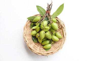 Bir grup taze ham Elaeocarpus hygrophilus meyvesi ikiye bölünmüş ve tüm yeşil yaprak beyaz arka planda izole edilmiş ahşap bir sepet içinde. Sağlıklı meyvelerin buruk, tatlı ve ekşi bir tadı vardır..