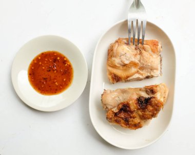 Sulu ve lezzetli ızgara tavuk veya kızarmış tavuk Serve Tavuk Sosu ile seramik bir tabakta düzenlenir.