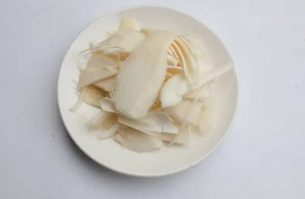 stock image Fresh Sliced Bamboo shoot, Bamboo sprout (Bambusa spp) in white plate isolate on a white backdrop.Edible bamboo that breaks from underground rhizomes.Vegetables and healthy food