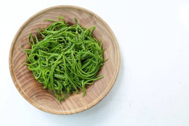 Sazan ya da Akasya yapraklarına tırmanan Cha-om acacia pennata (l.) willd. Beyaz bir plaka içinde, beyaz bir arkaplanda izole edilmiş. Tayland yemeği pişirmek için hammadde, iyi faydalar ve sağlıklı olmak için yüksek vitaminler. 