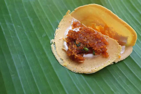 stock image  Khanom Bueang,Thai crispy pancakes. White cream made from egg whites mixed with sugar, beaten until smooth like whipping cream. Garnish with foi thong or fried shredded shrimp on a banana leaf