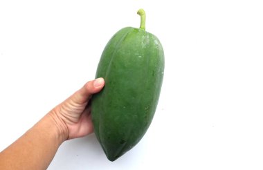Tayland 'da papaya salatası ya da Som Tam menüsünü hazırlamak için beyaz bir fon üzerinde kadınların elinde çiğ papayalar. Papaya salatası baharatlı, Tayland yemeği, geleneksel Tayland yemeği.