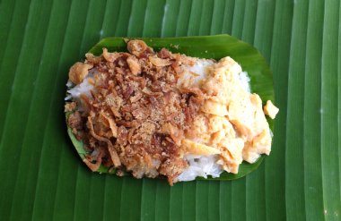 Tayland tatlısı, iştah açıcı yumurtalı pilav, kurutulmuş balık muz yeşili yaprağında izole edilmiş.