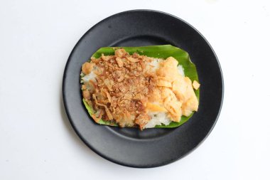 Tayland tatlısı, iştah açıcı yumurtalı pilav, kurutulmuş balık, siyah tabakta izole edilmiş beyaz bir zemin üzerinde.