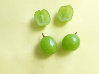 Bir demet taze tatlı yeşil muscat (Vitis vinifera) üzümü sarı arka fonda izole edilmiş. Yeşil üzümler. Japon üzümleri. Üzüm yeşili. Tadı tatlı ve doğal..