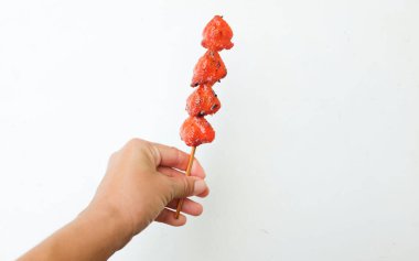 delicious ,Juicy Chicken butt grilledin woman's hand isolated on white backdrop. BBQ chicken butt. Grilled chicken butt skewer. Halal food. Traditional street food in Thailand
