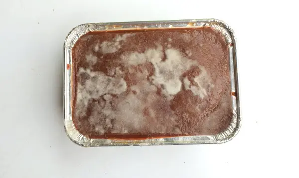 stock image moldy sweet chocolate bread or Moldy mold on chocolate pudding close up in a plastic container.Unhealthy food,on chocolate cake with moldy.