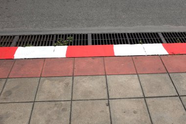 Caddenin dibindeki asfalt döşeme dokusu beton tuğla kare taş zemin zemin zemin döşemesi beton döşeme döşeme döşeme döşemeleri, beton döşeme döşeme döşemeleri, yan manzara beton kaldırım ya da yaya yolu.