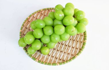 Bir demet taze Sweet Green Shine Muscat (Vitis vinifera) üzümü ahşap sepeti izole ediyor. Japon üzümleri. Üzüm yeşili. Tadı tatlı ve doğal..