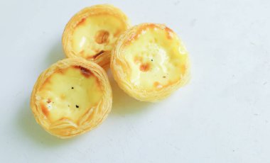 Bir yığın taze yumurtalı tart fırında tatlı tatlı tatlı, Pastel de nata turtası ya da turta Portekiz yumurtalı tartı beyaz bir arka planda izole edilmiş..