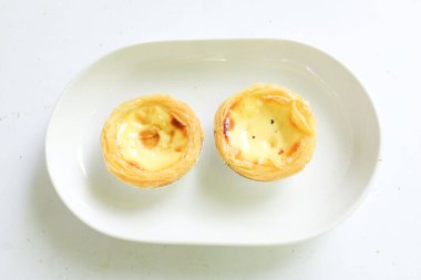 Bir yığın taze yumurtalı tart fırında tatlı tatlı kek, Pastel de nata turtası ya da turta Portekiz usulü yumurta turtası, beyaz bir arka planda yalıtılmış..