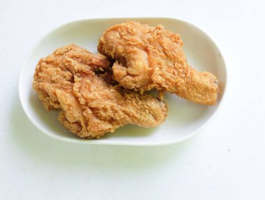 Sulu ve lezzetli tavuk budu ya da kızarmış tavuk budu, kızarmış tavuk budu beyaz seramik bir tabakta kızarmış tavuk bacağı, beyaz bir arka planda izole edilmiş.